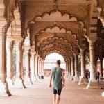 man walking under traditional arch