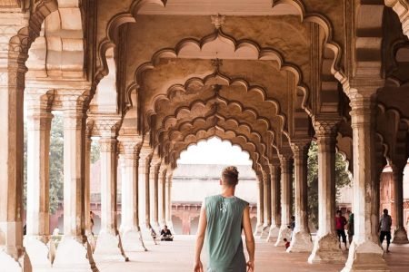 man walking under traditional arch